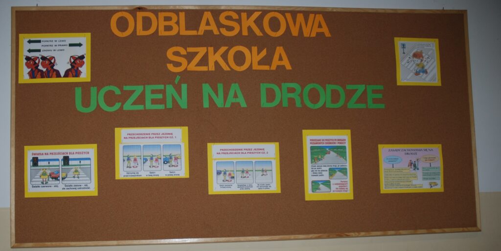 Tablica korkowa z napisem odblaskowa szkoła uczeń na drodze. Na tablicy również różne informacyjne plakaty